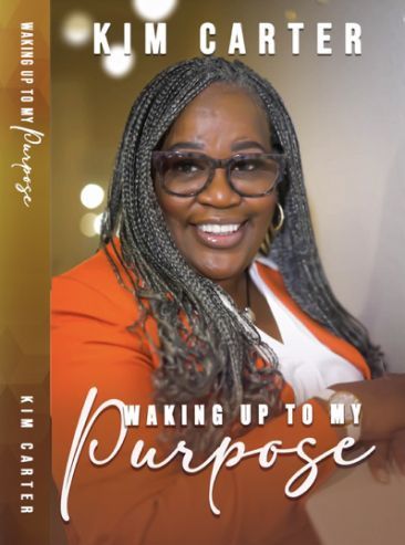 Book cover featuring Kim Carter smiling, wearing glasses and an orange blazer. The title reads "Waking Up to My Purpose" with her name at the top and on the spine.